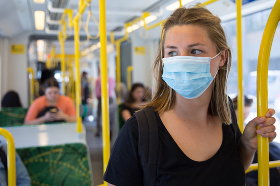 A person with a mask riding public transportation