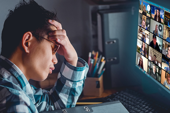 Person holding their head in hand during a virtual conference call