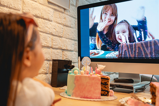 Child celebrating birthday over virtual call
