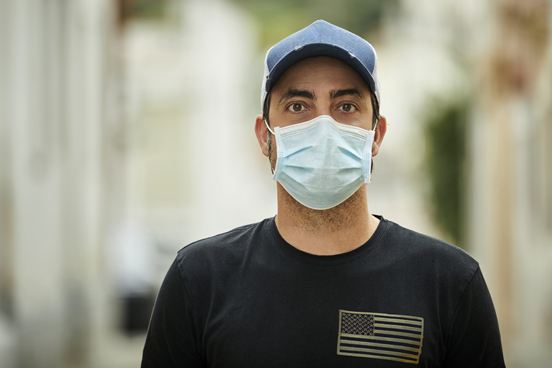 Veteran in a mask and shirt with American flag graphic.