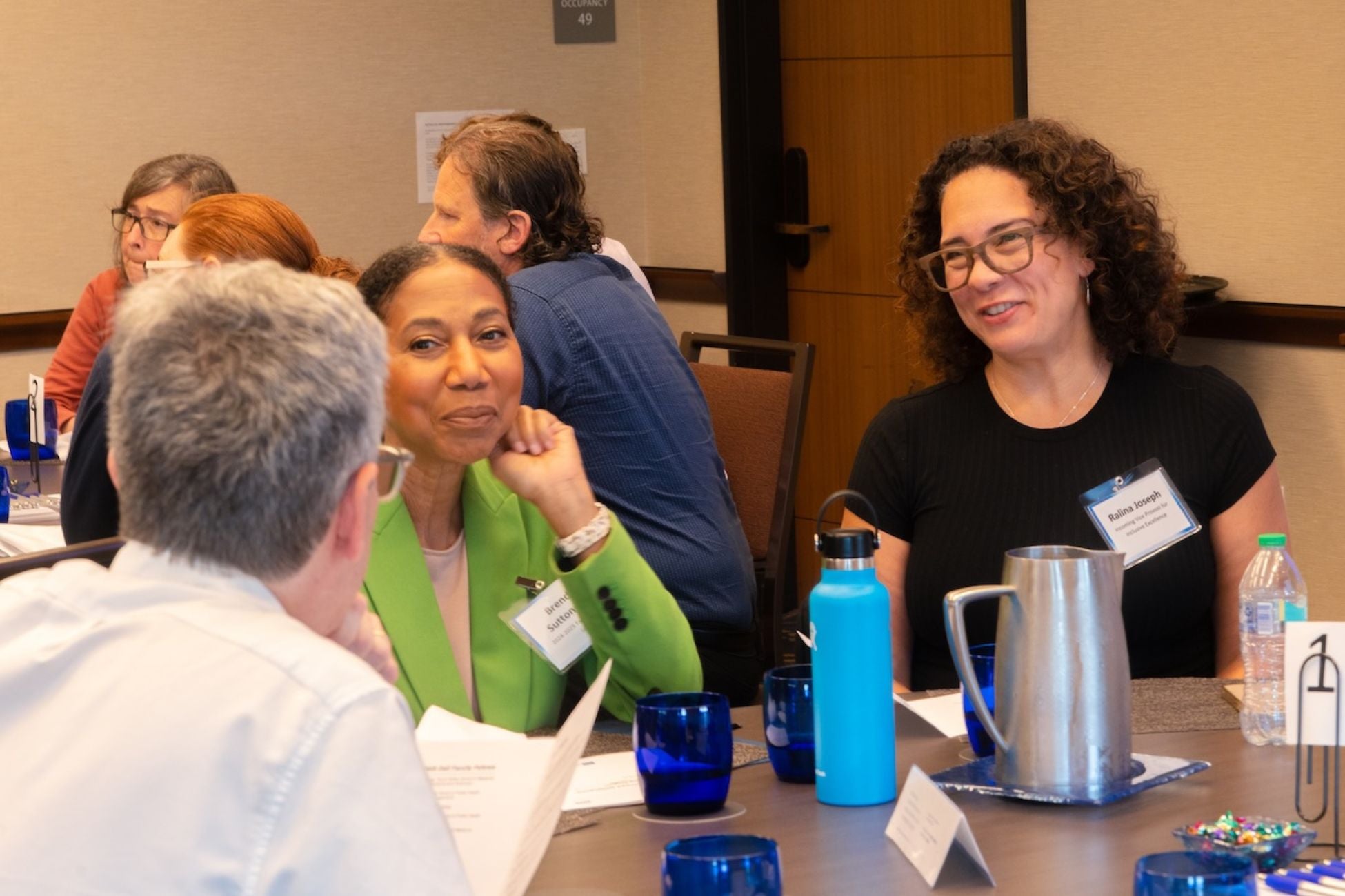 Three individuals sitting at a table, actively discussing and sharing ideas