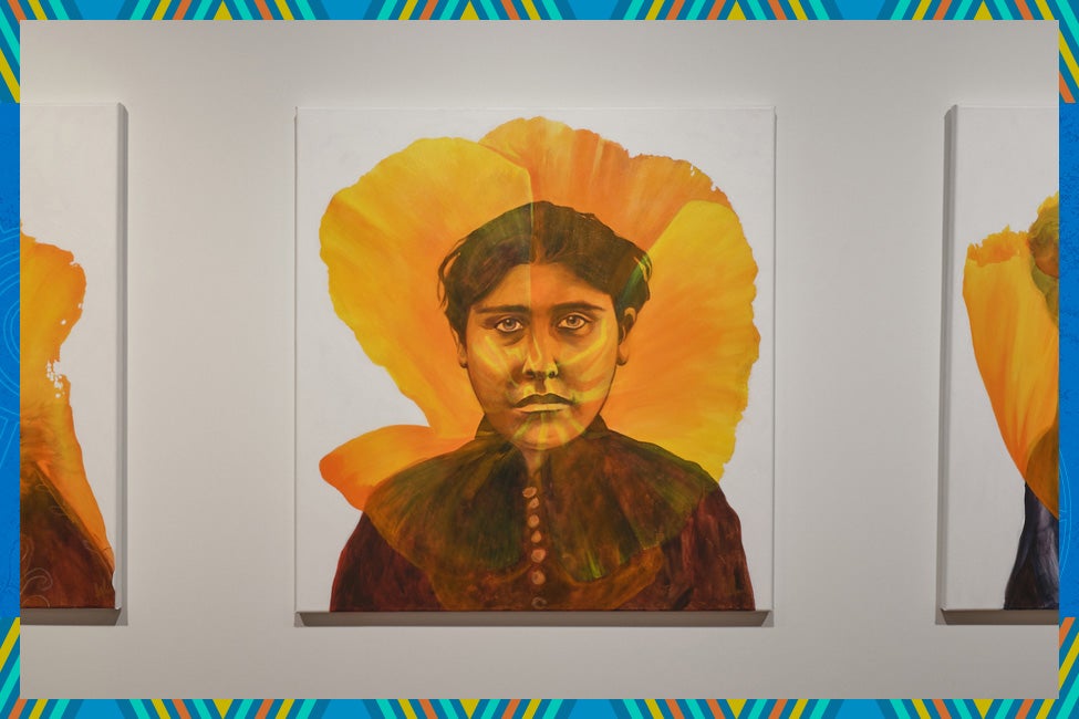 A vivid painting portrays a serious-looking woman with short dark hair, wearing a dark blouse. A vibrant yellow-orange flower forms a halo behind her.