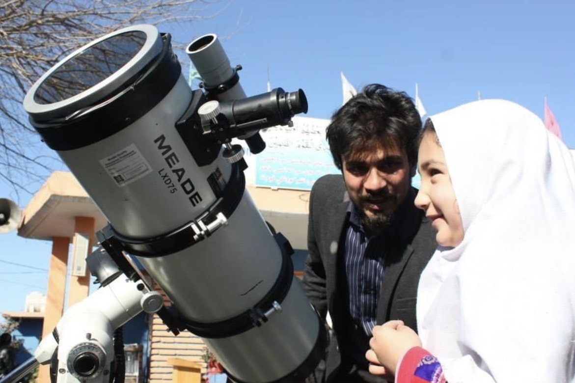 Abrahim Amiri with young girl and a telescope