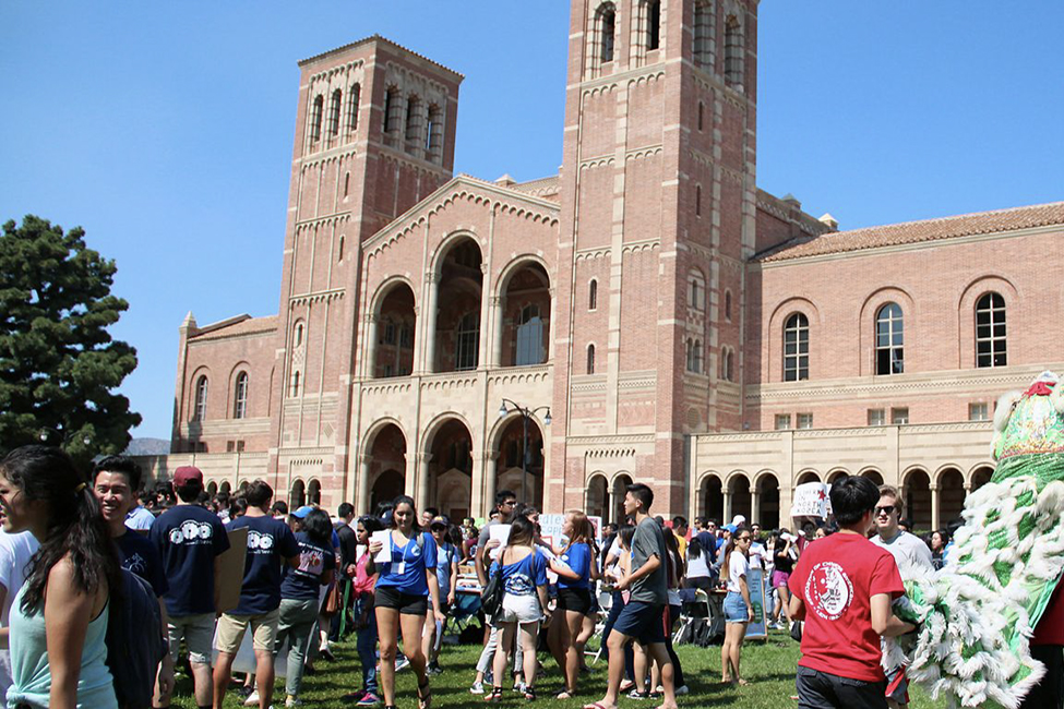 A crowd of students gathered in front of Royce Hall walking around