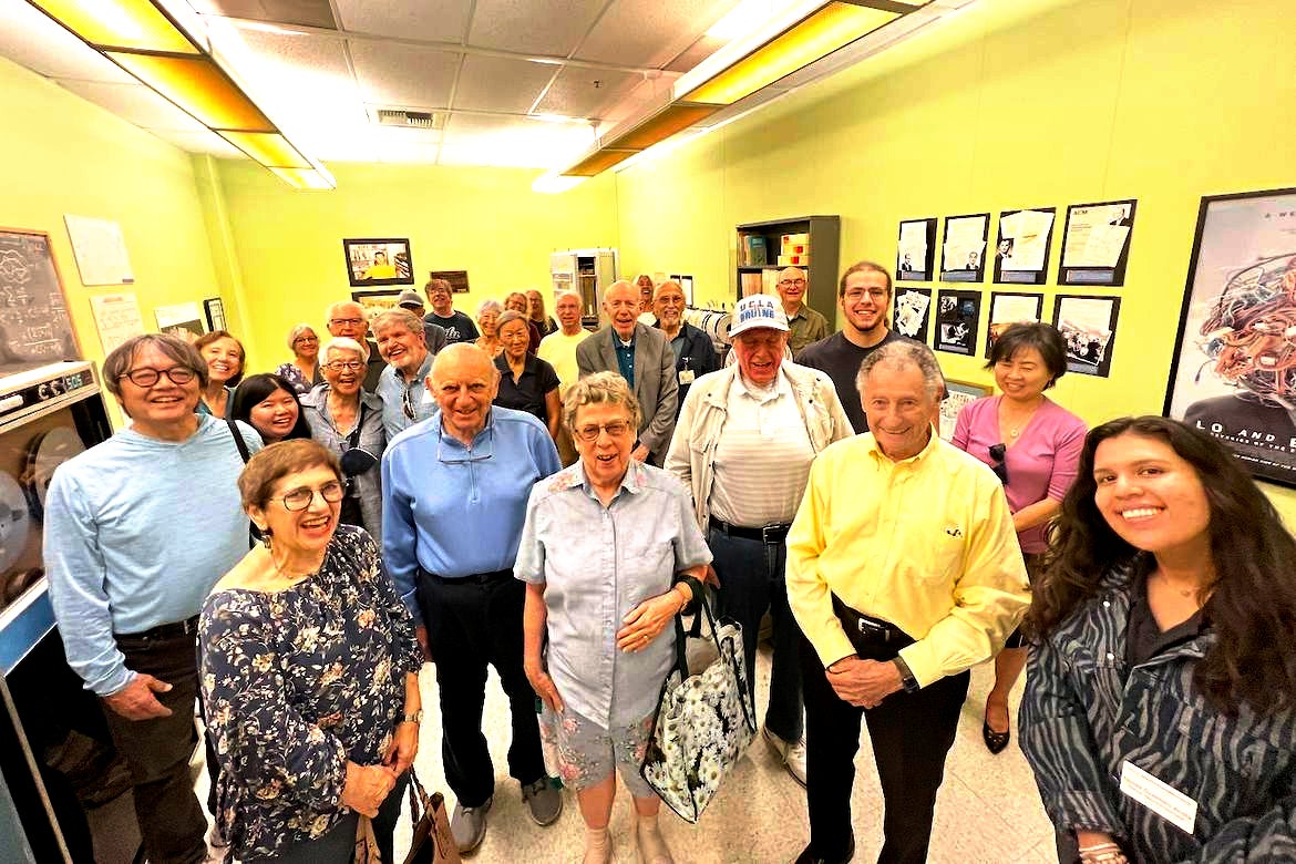 Retirees and UCLA professor Leonard Kleinrock pose for a photo inside a room