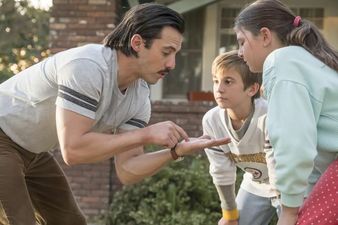 Actor Milo Ventimiglia sketches on hand while two child actors watch