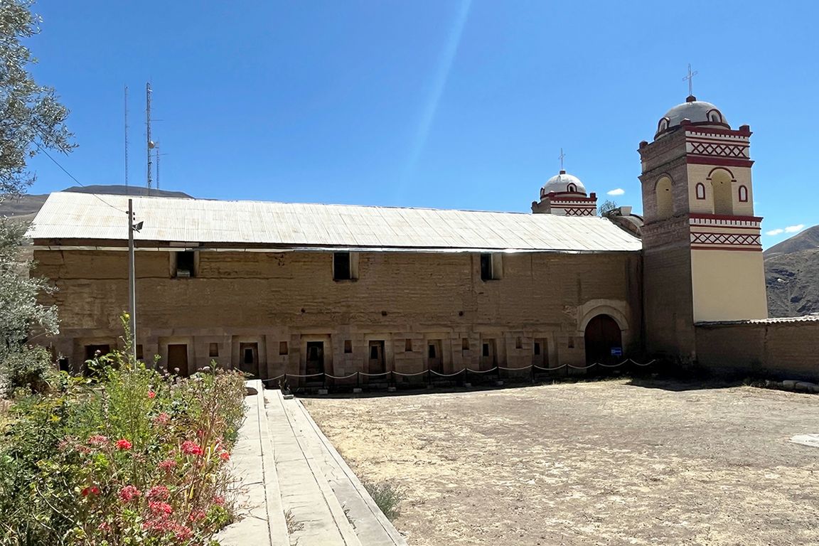 Outside shot of a two-story stone building and a barren courtyard