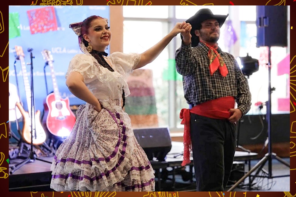 A woman and man stand smiling and dancing