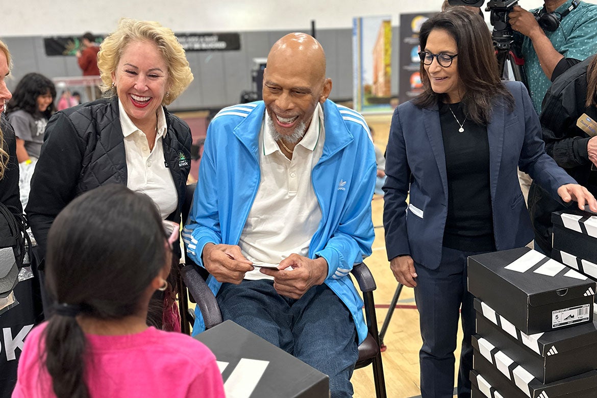 Kareem Abdul-Jabbar (center) speaks with a UCLA Community School student at the “Lace Up for Learning” event on Nov. 17.