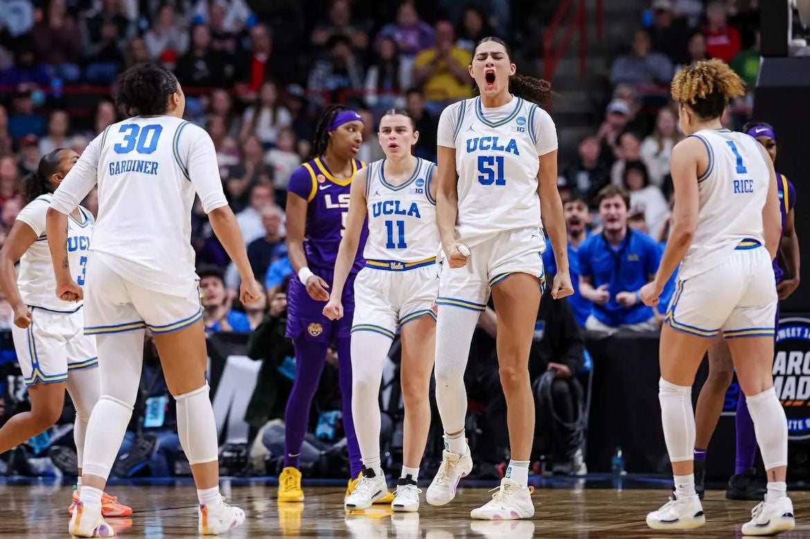 UCLA women's basketball team members celebrate on the court