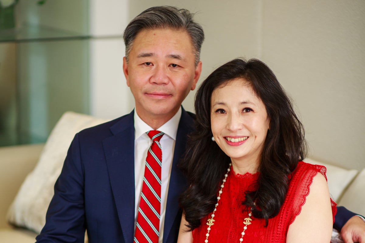 Walter Wang, left, in blue suit and red tie, sitting next to Shirley Wang in red top