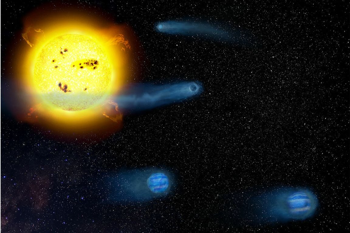 Star V1298 in yellow and four baby planets, in blue, against black background