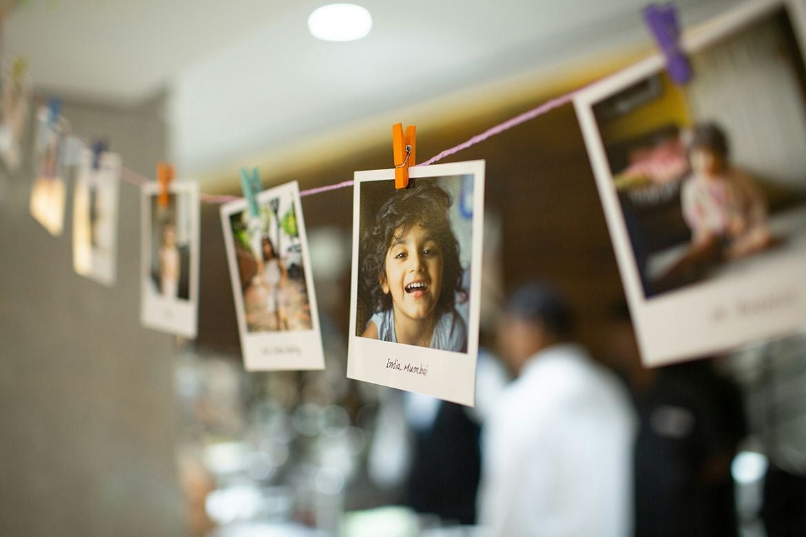 Polaroid photos on a string. Most of the images are blurry, but the clear one is the head of a smiling child