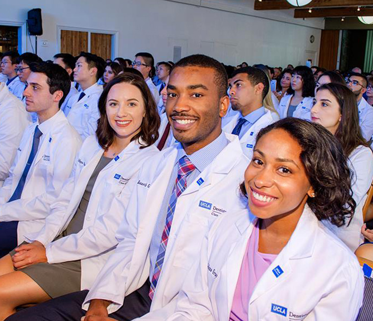 Dentistry students in their white coats attending a conference