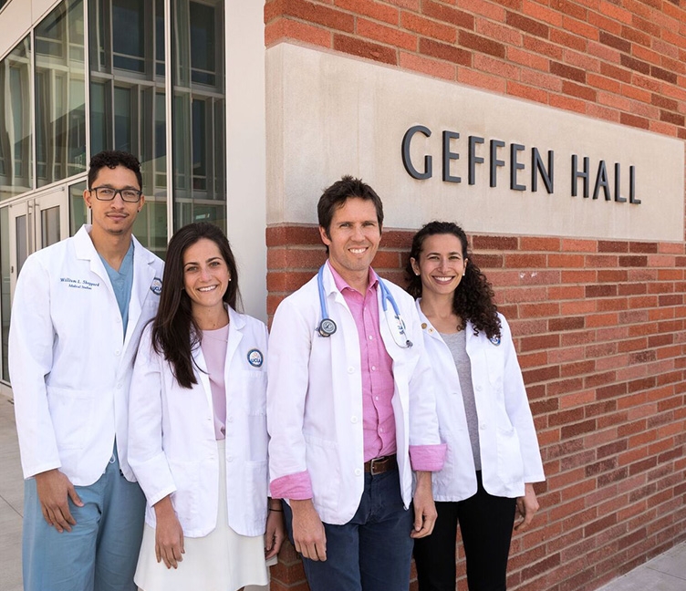 Four medical students stand in front of Geffen Hall.