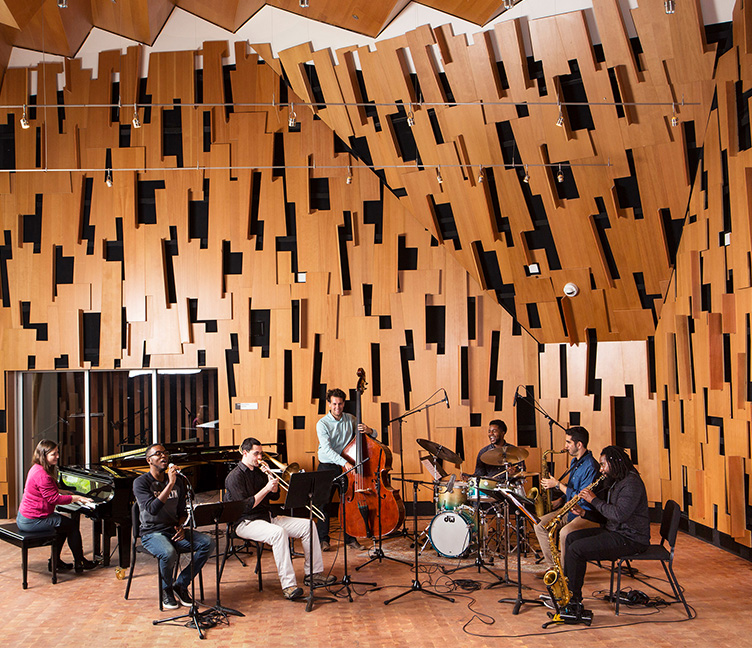 Students play instruments inside a recording studio.