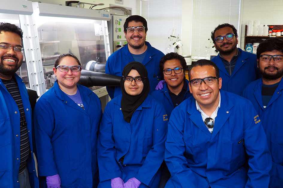 Professor Osvaldo Gutierrez in blue lab coats and safety googles with a team of seven researchers.
Beating brain cancer